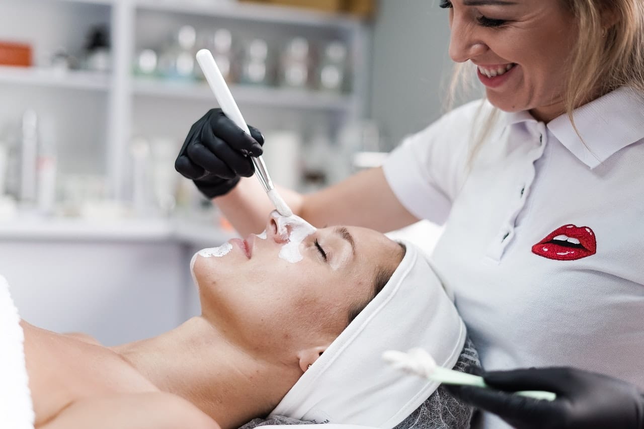 profissional de estética realizando procedimento com equipamento em face de uma cliente